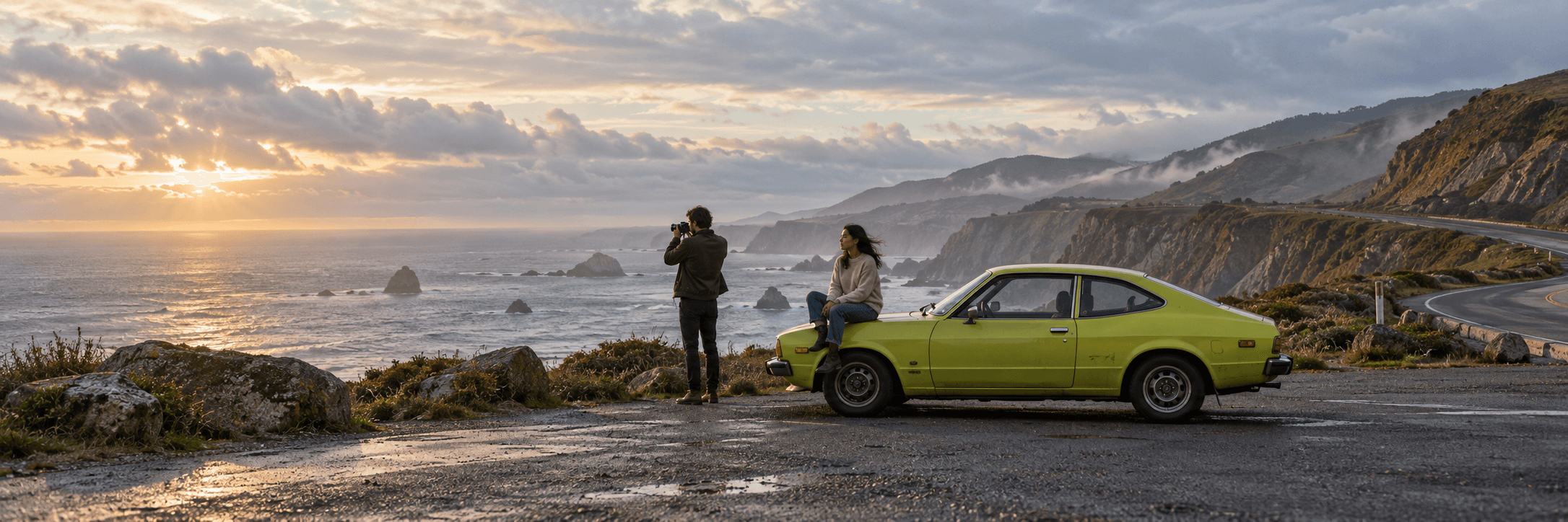 Two people beside a lime-colored vintage car on a dramatic coastal road at sunset